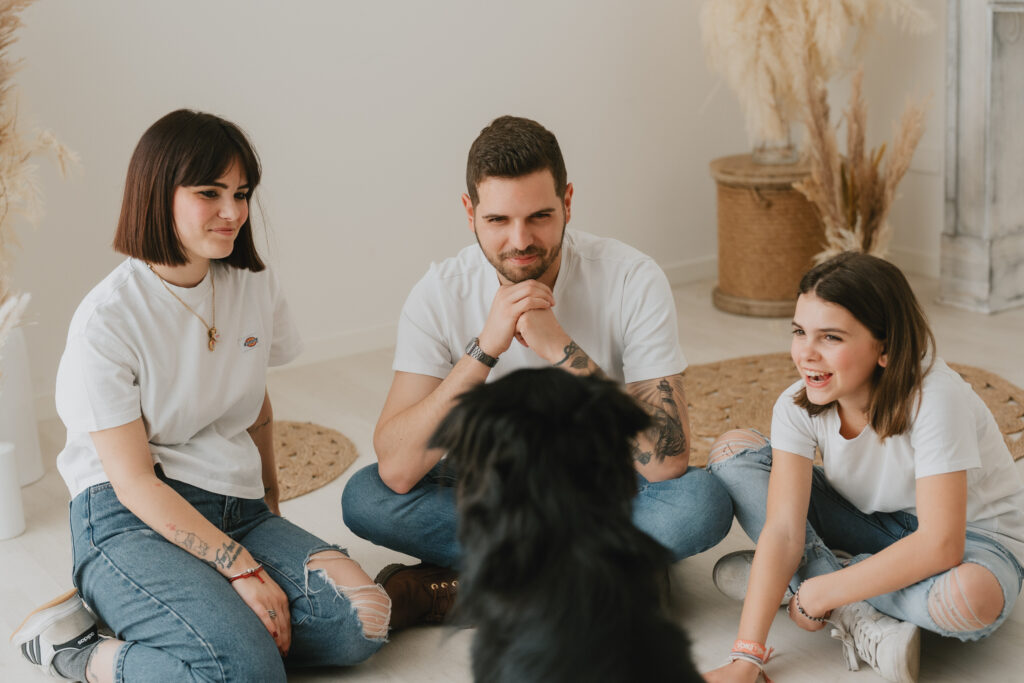Servizio fotografico di famiglia in studio a Firenze con momento spontaneo tra genitori, figlia e cane