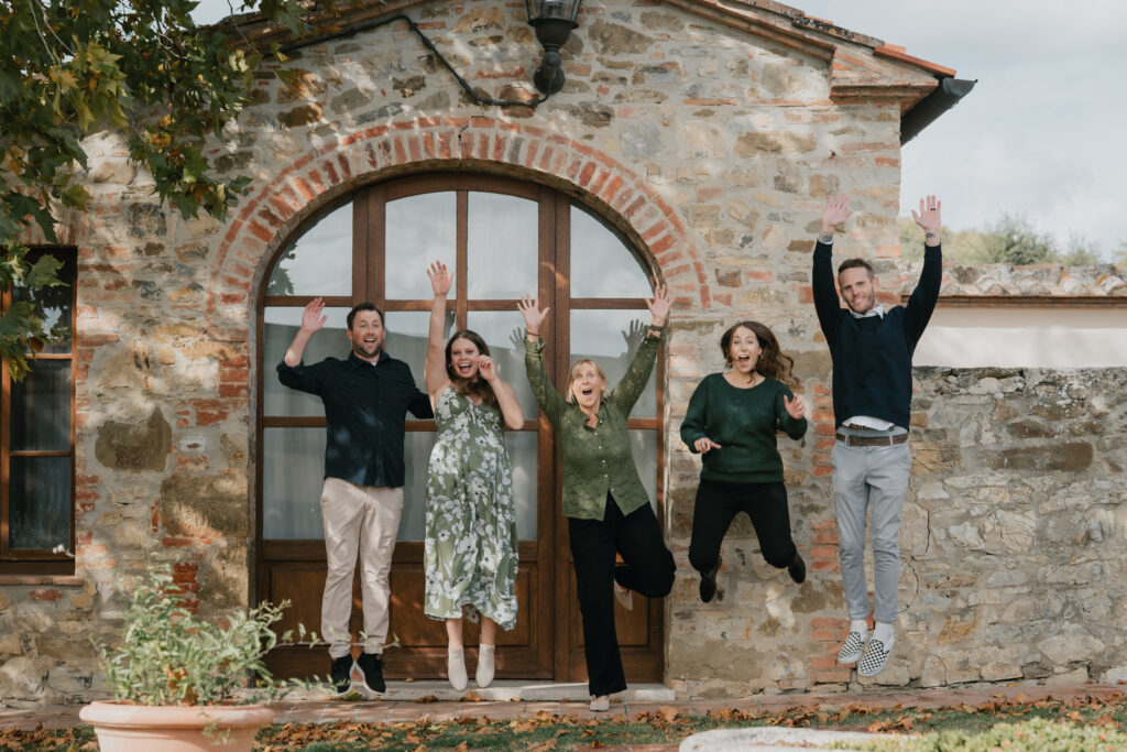 Servizio fotografico di famiglia in Toscana con momento spontaneo e divertente davanti a casa
