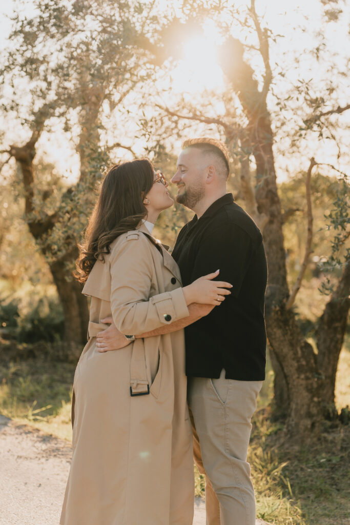 Surprise proposal photoshoot in the Tuscan countryside: the couple embracing among olive trees at sunset