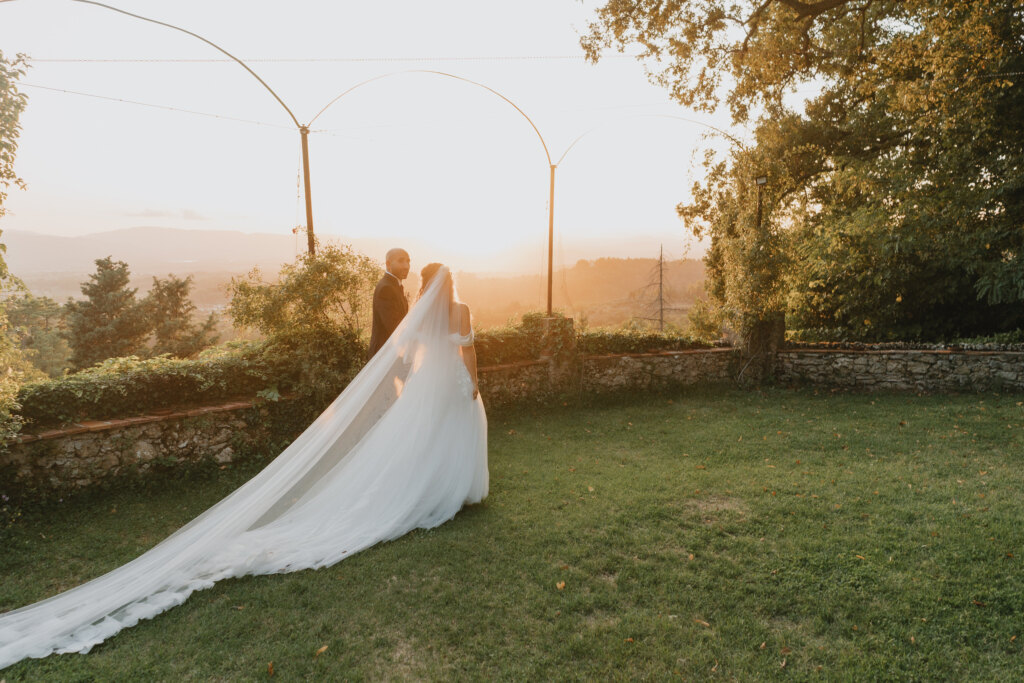 Wedding photographer at Villa di Striano: newlyweds at sunset in the garden with the veil spread out on the lawn