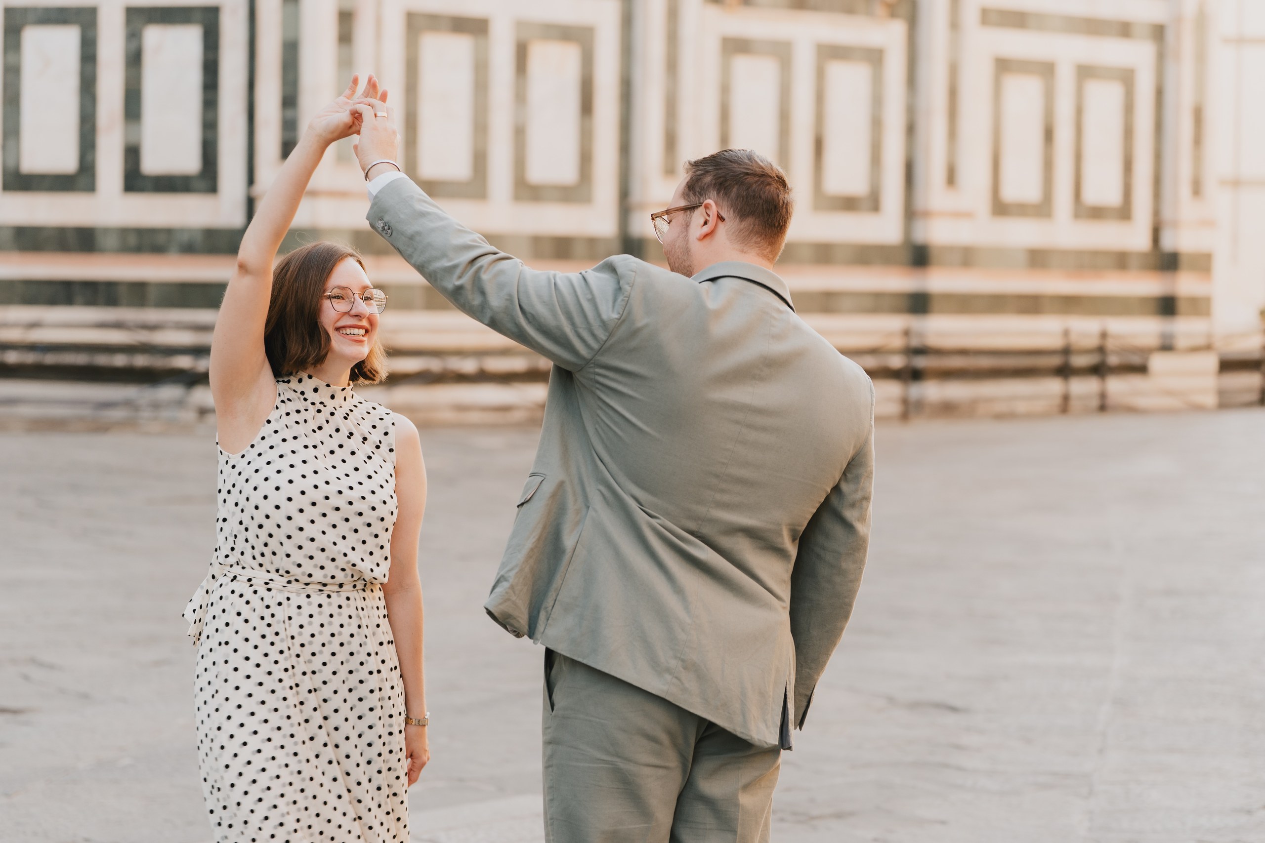 Couple dancing on the square in front of the marble walls of the Duomo, Florence