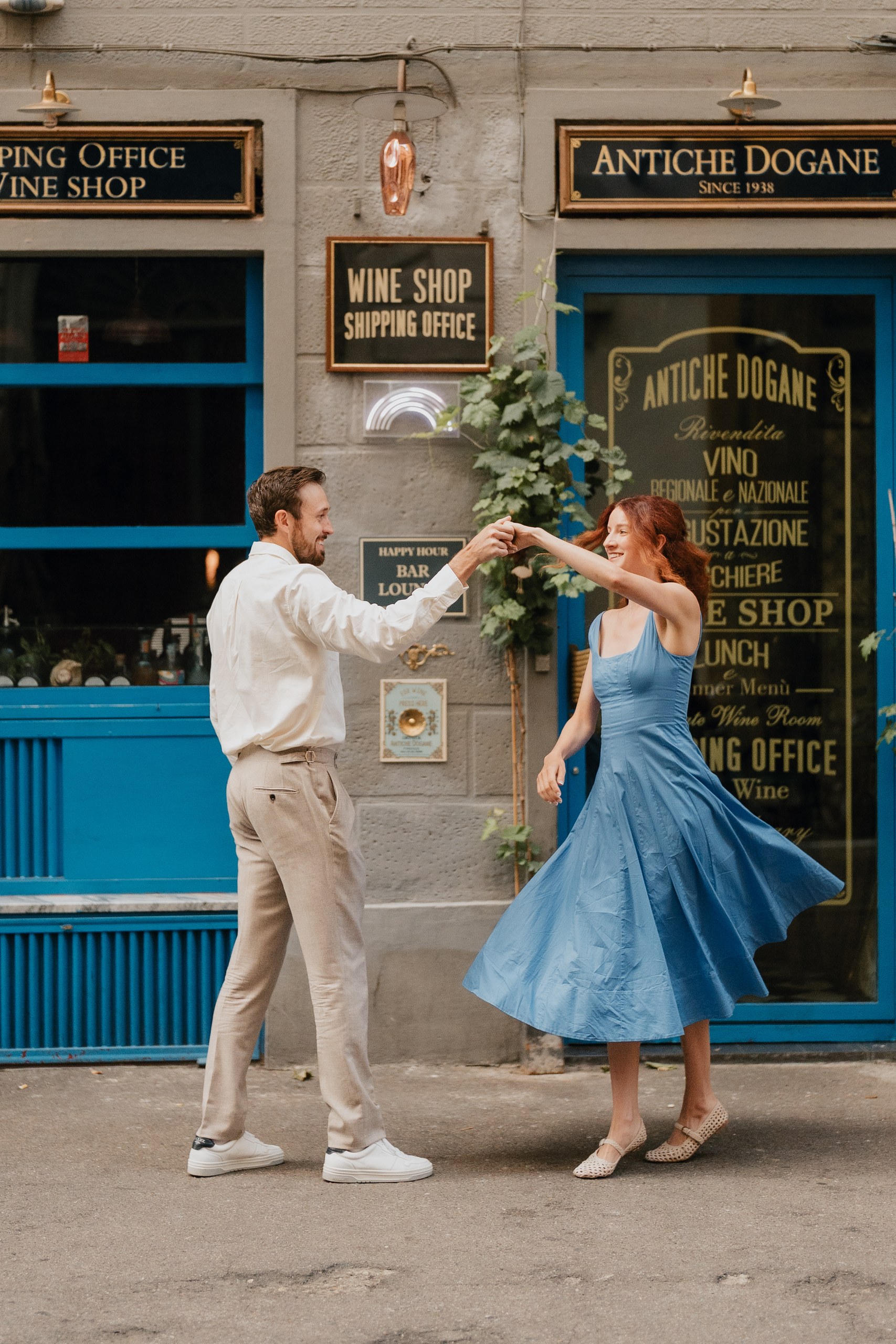 Couple dancing in front of an old shop front in the centre of Florence