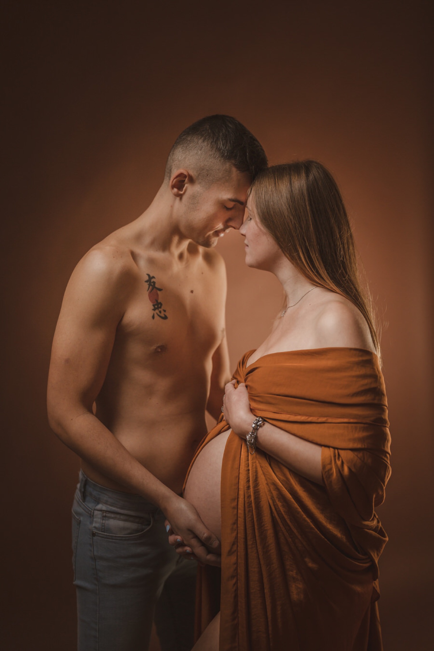 Coppia fronte contro fronte, le mani sul pancione