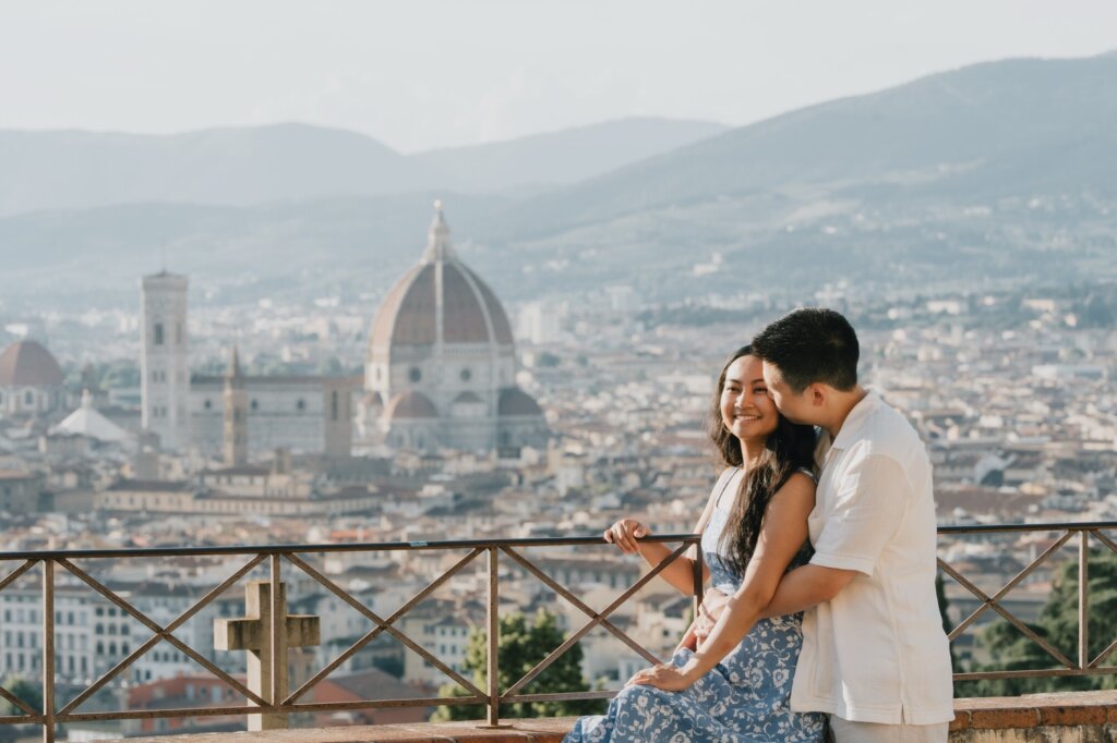 Coppia appoggiata alla ringhiera davanti al Duomo e a Palazzo Vecchio