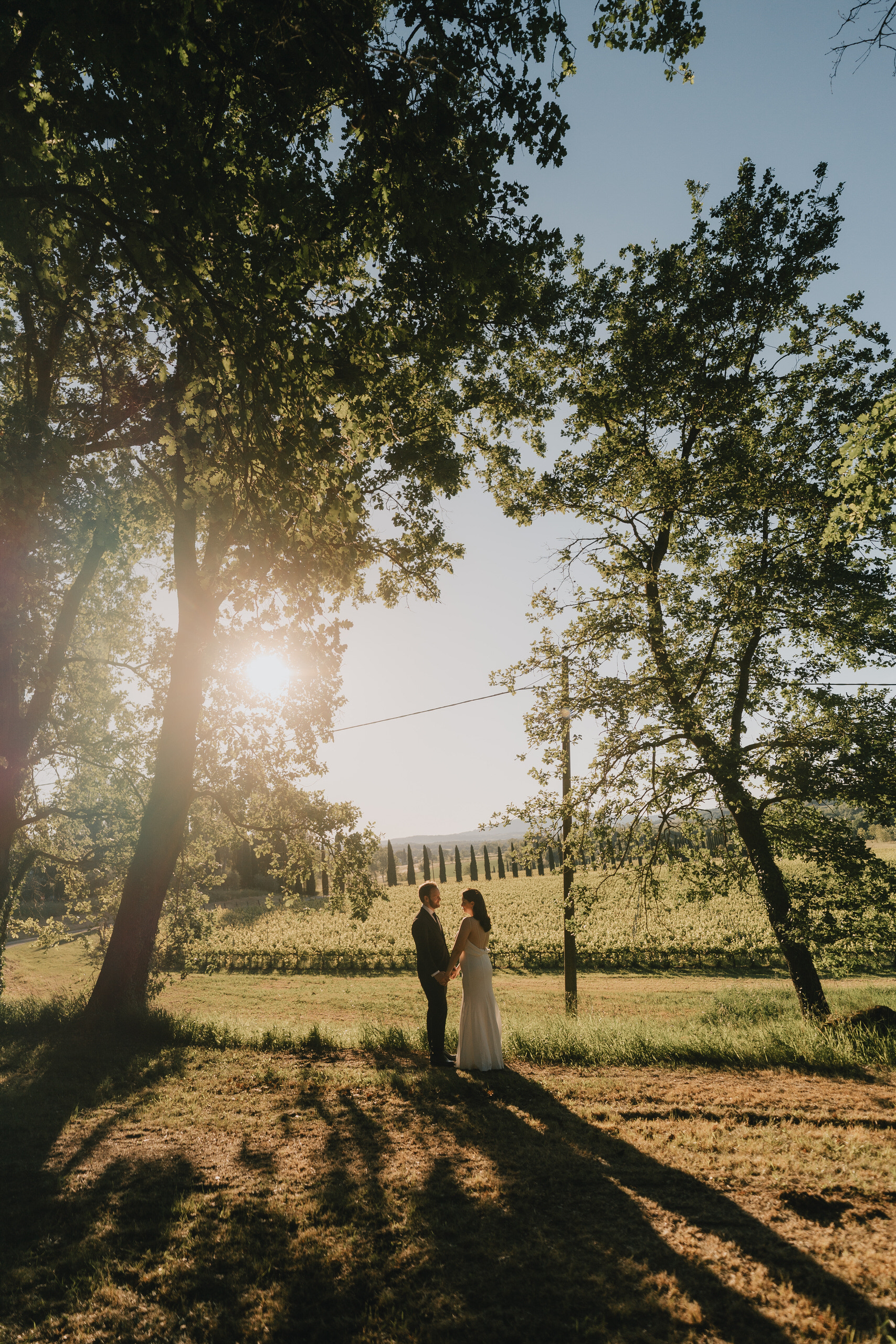 Couple under the trees with long shadows on the grass