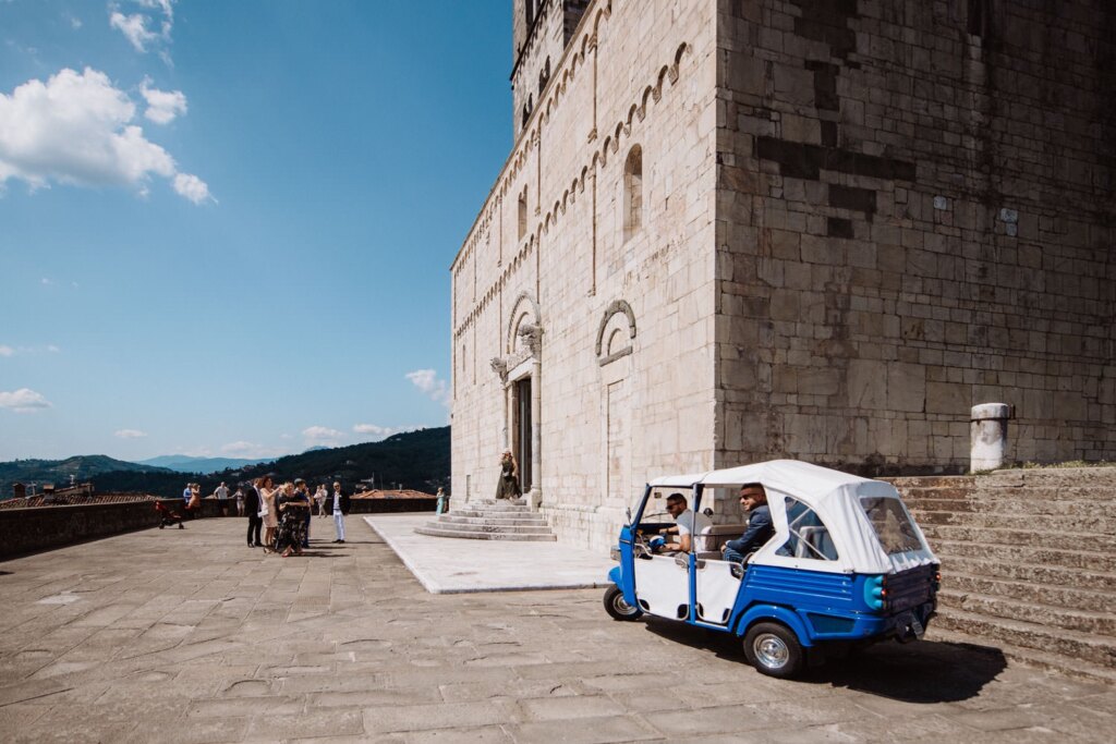 The light blue Ape Calessino in front of the Duomo of Barga