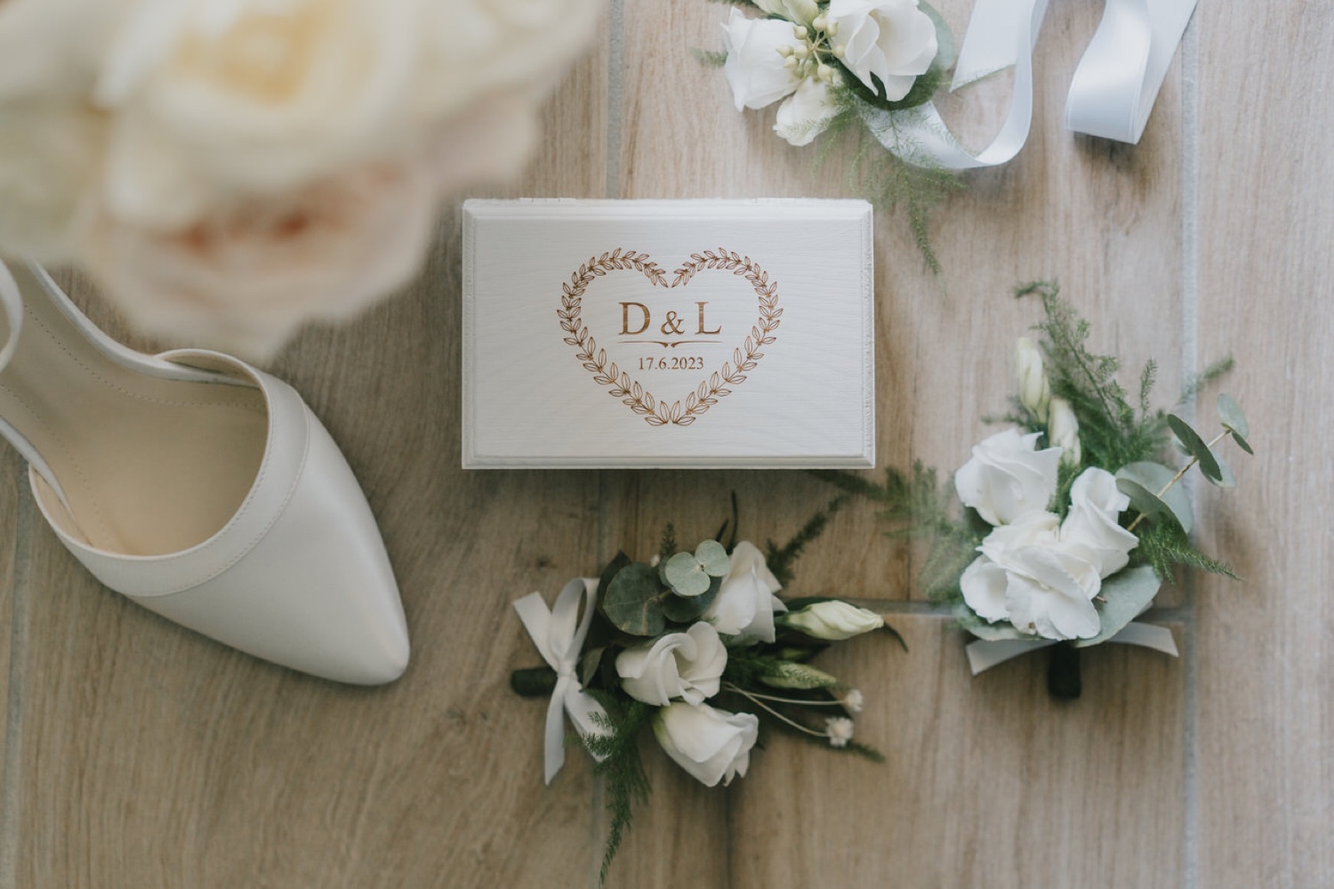Scarpe, scatola delle fedi e fiori bianchi della sposa
