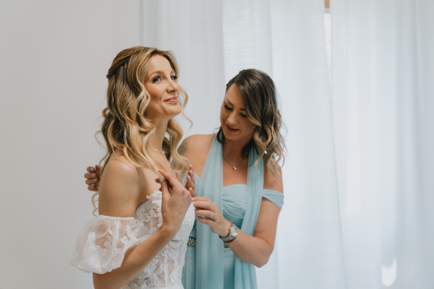 Un'amica sistema l'abito della sposa