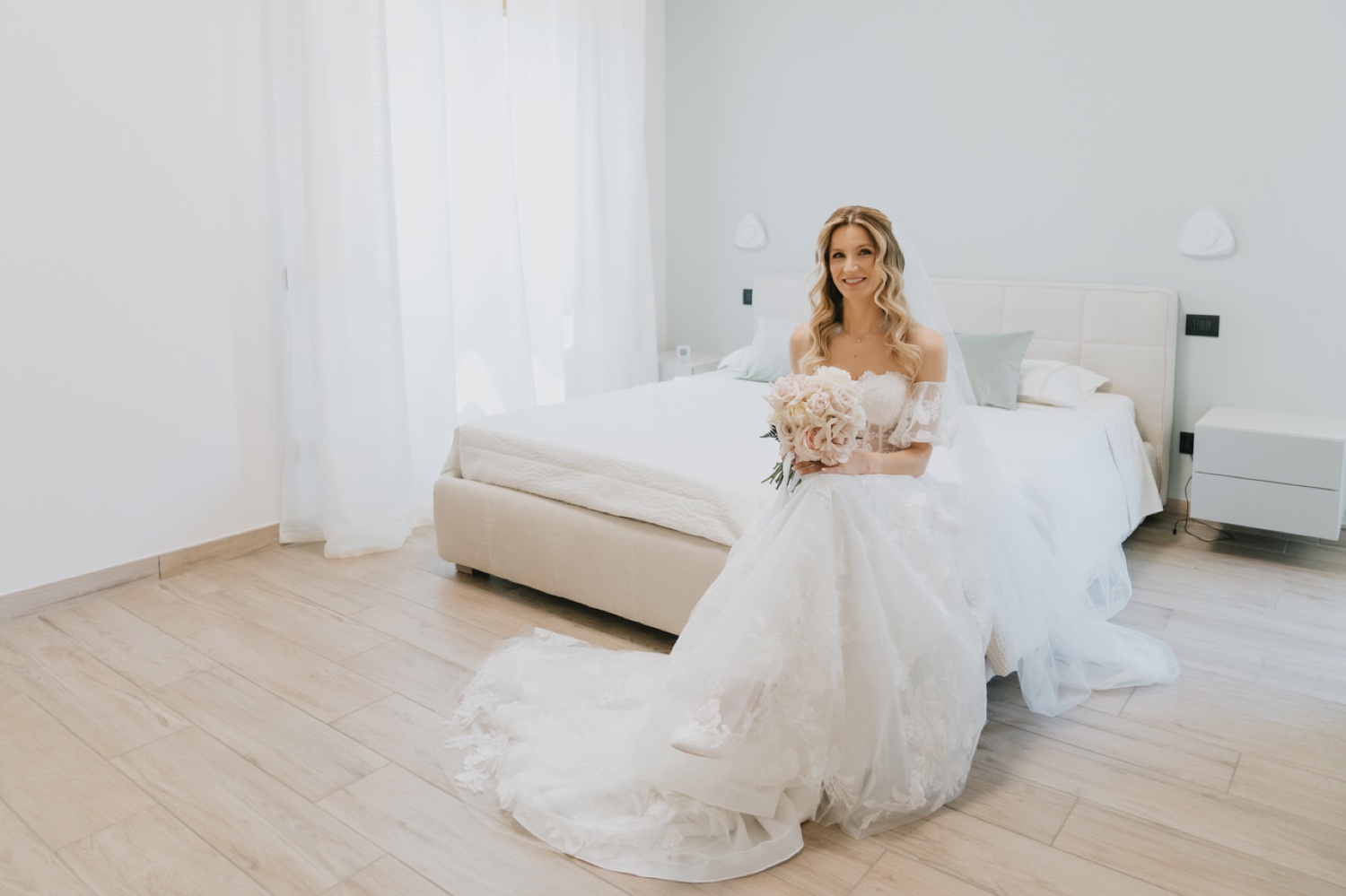 La sposa seduta sul letto con l'abito