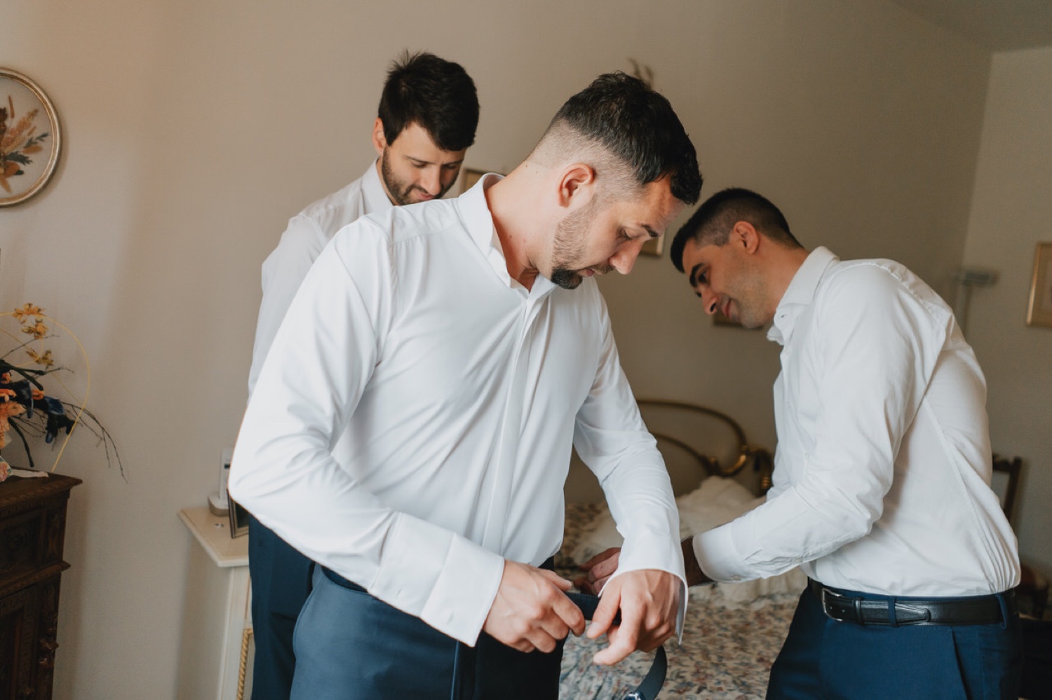 Gli amici aiutano lo sposo con la camicia