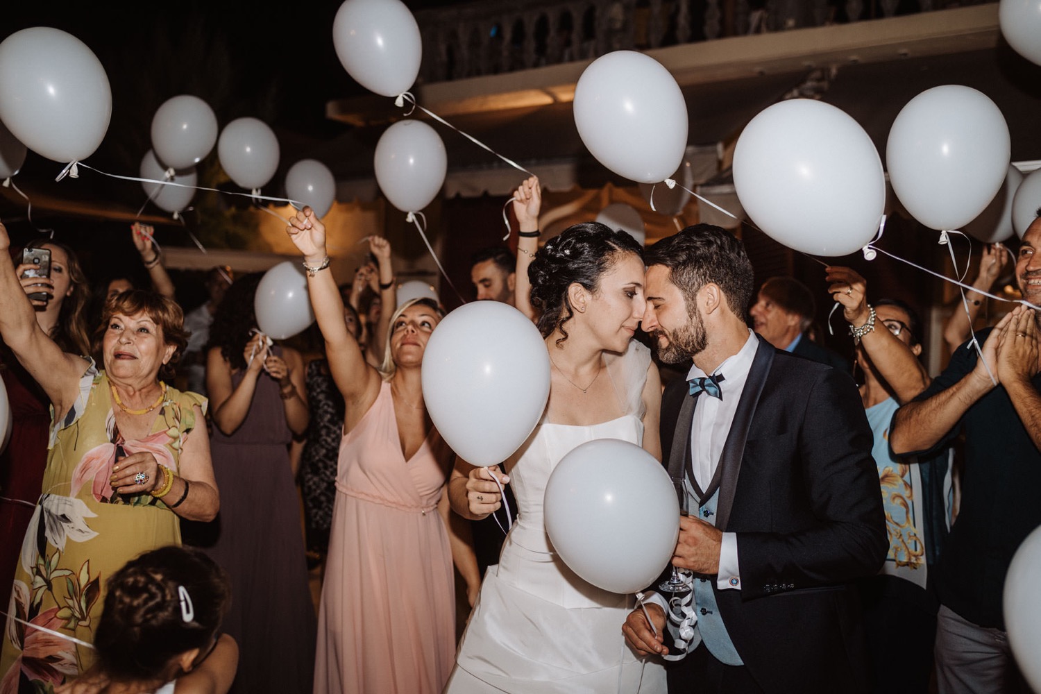 The couple kisses among the balloons