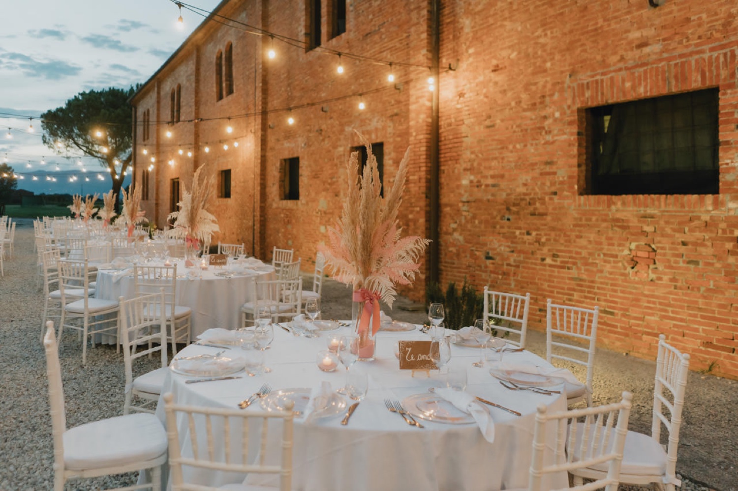 Matrimonio alla Fattoria Settepassi: i tavoli illuminati davanti al casale