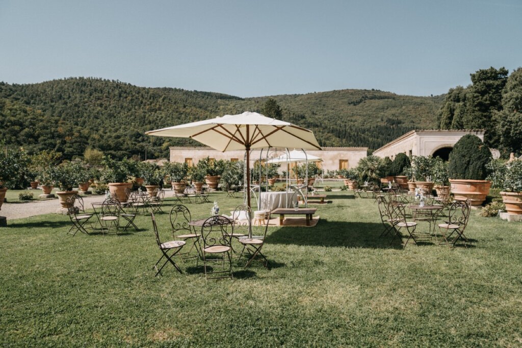 Il prato con i tavolini e gli ombrelloni bianchi per l'aperitivo