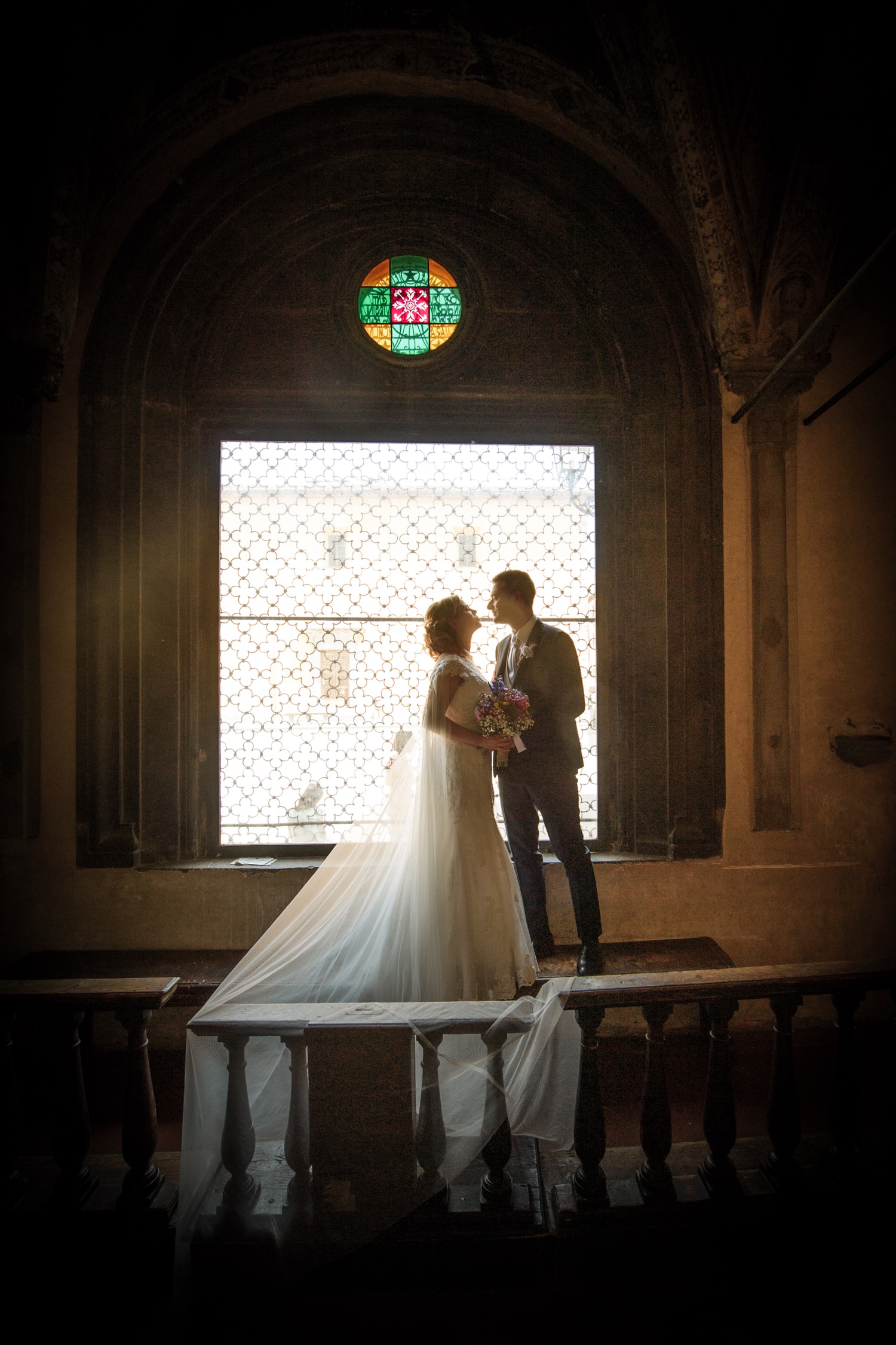 Matrimonio al Palazzo dei Vicari: gli sposi controluce alla finestra