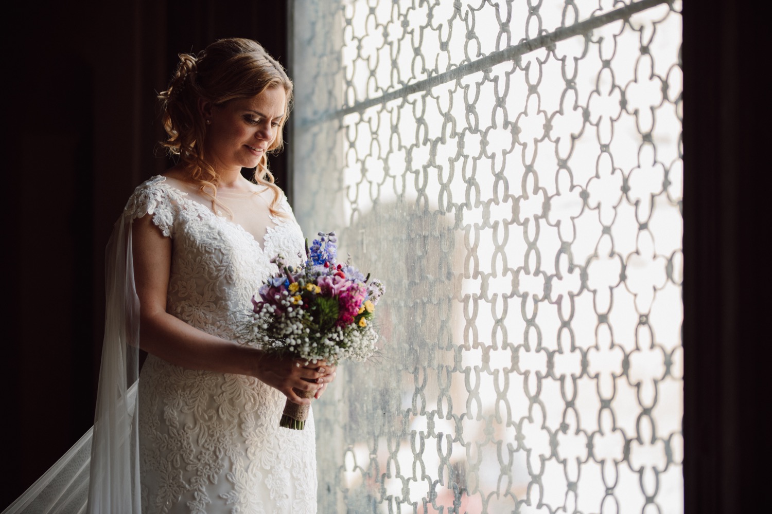 La sposa con il bouquet alla vetrata