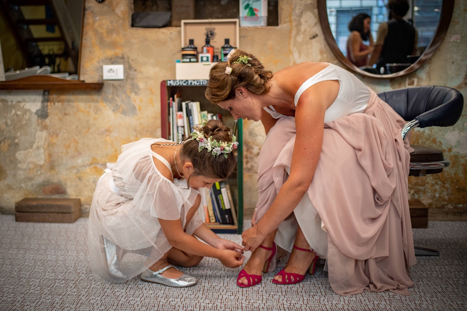 La sposa e la bambina allacciano le scarpe