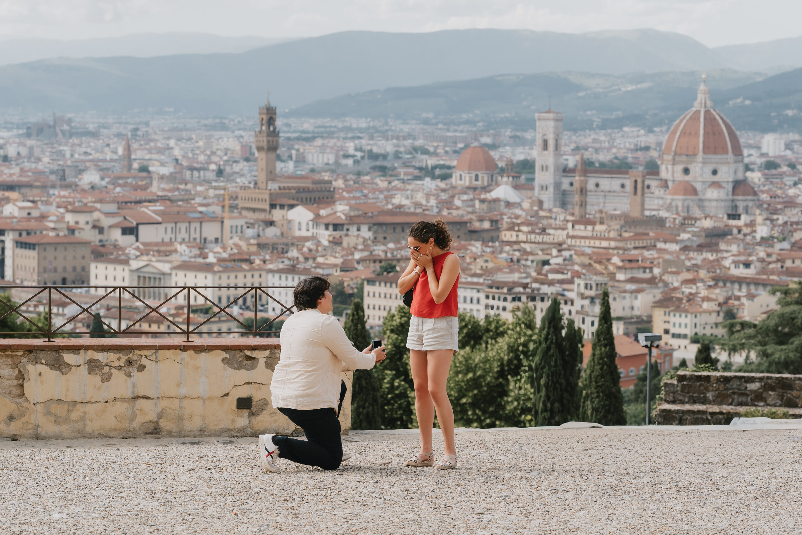Wide view of a proposal above Florence with the whole city skyline behind the couple