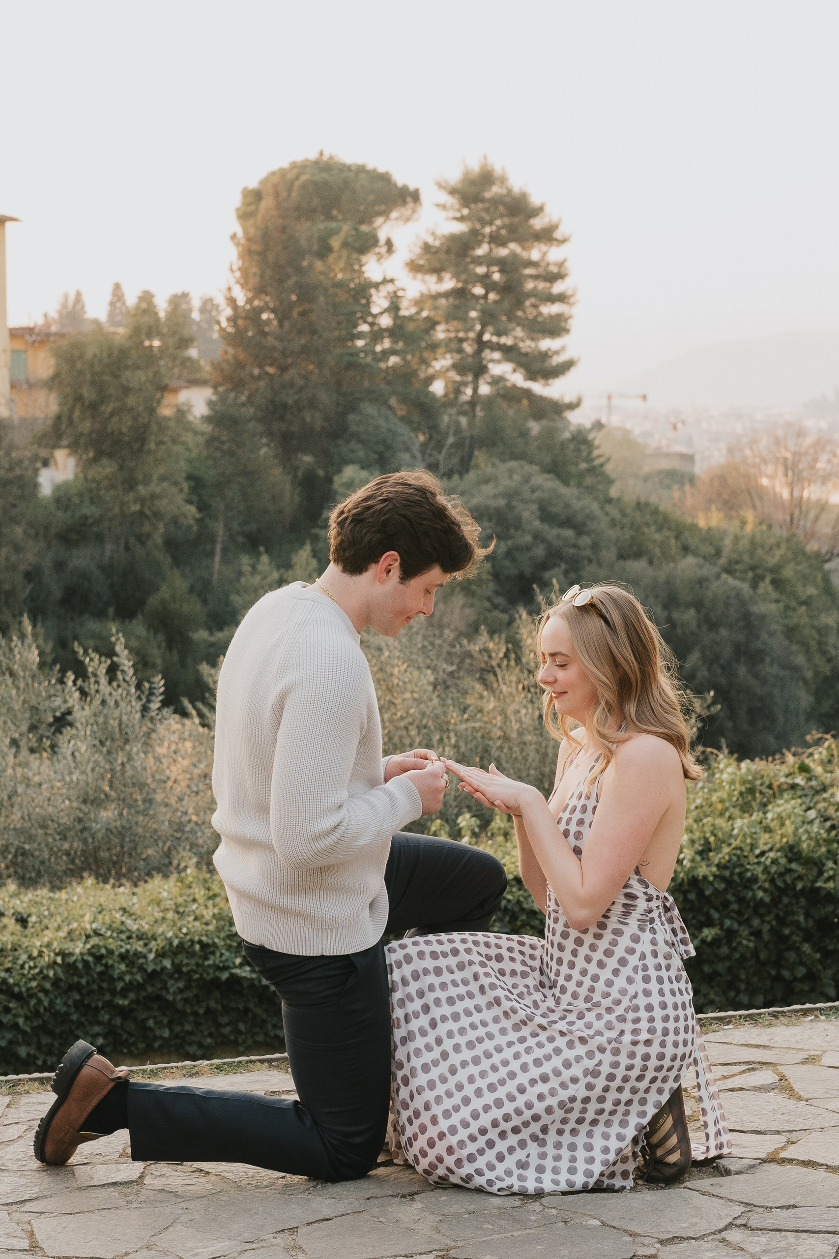 Vertical photo of a proposal on a stone terrace above Florence among cypresses