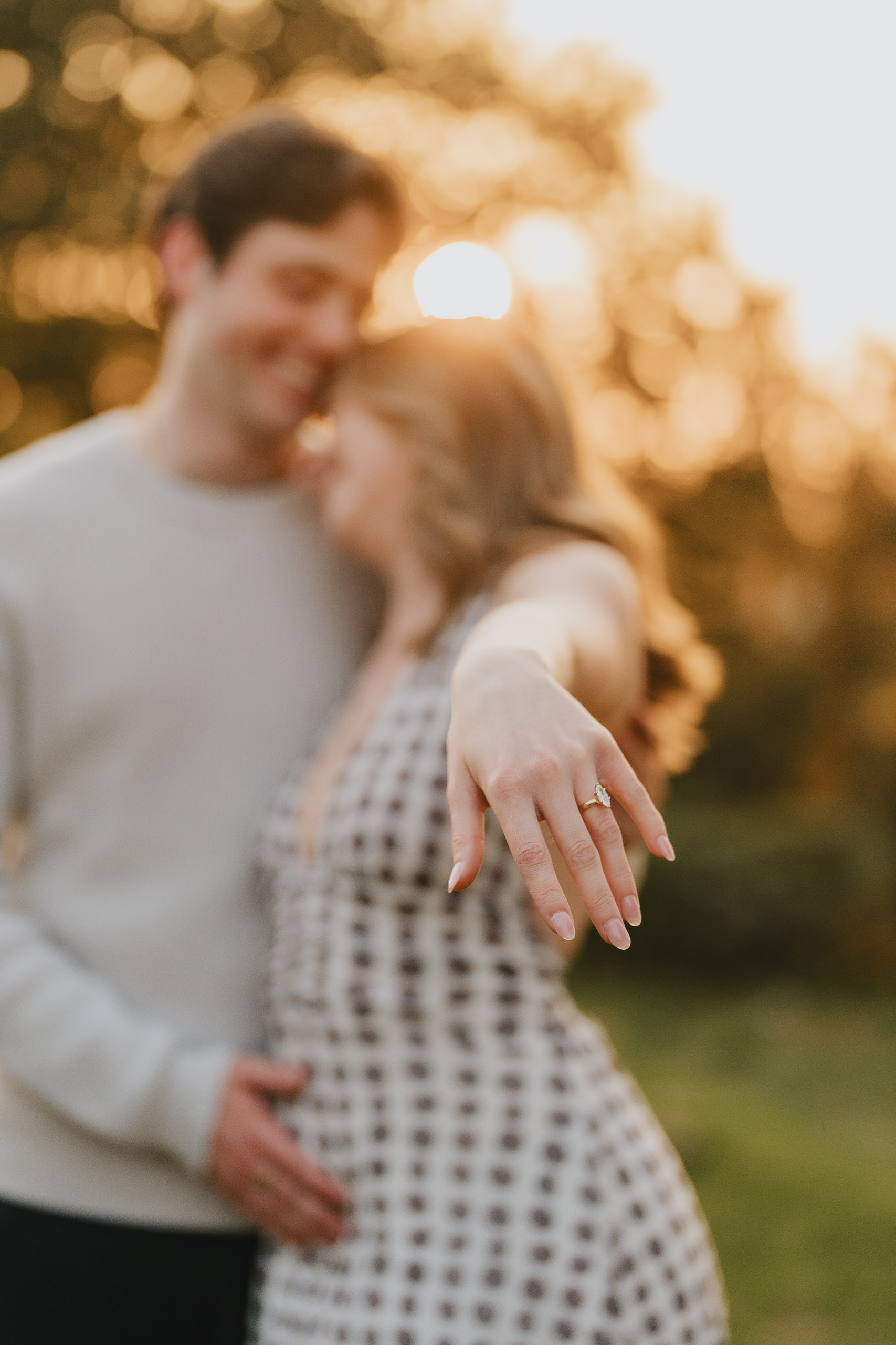 She shows the ring while he hugs her, golden light after a proposal in Florence