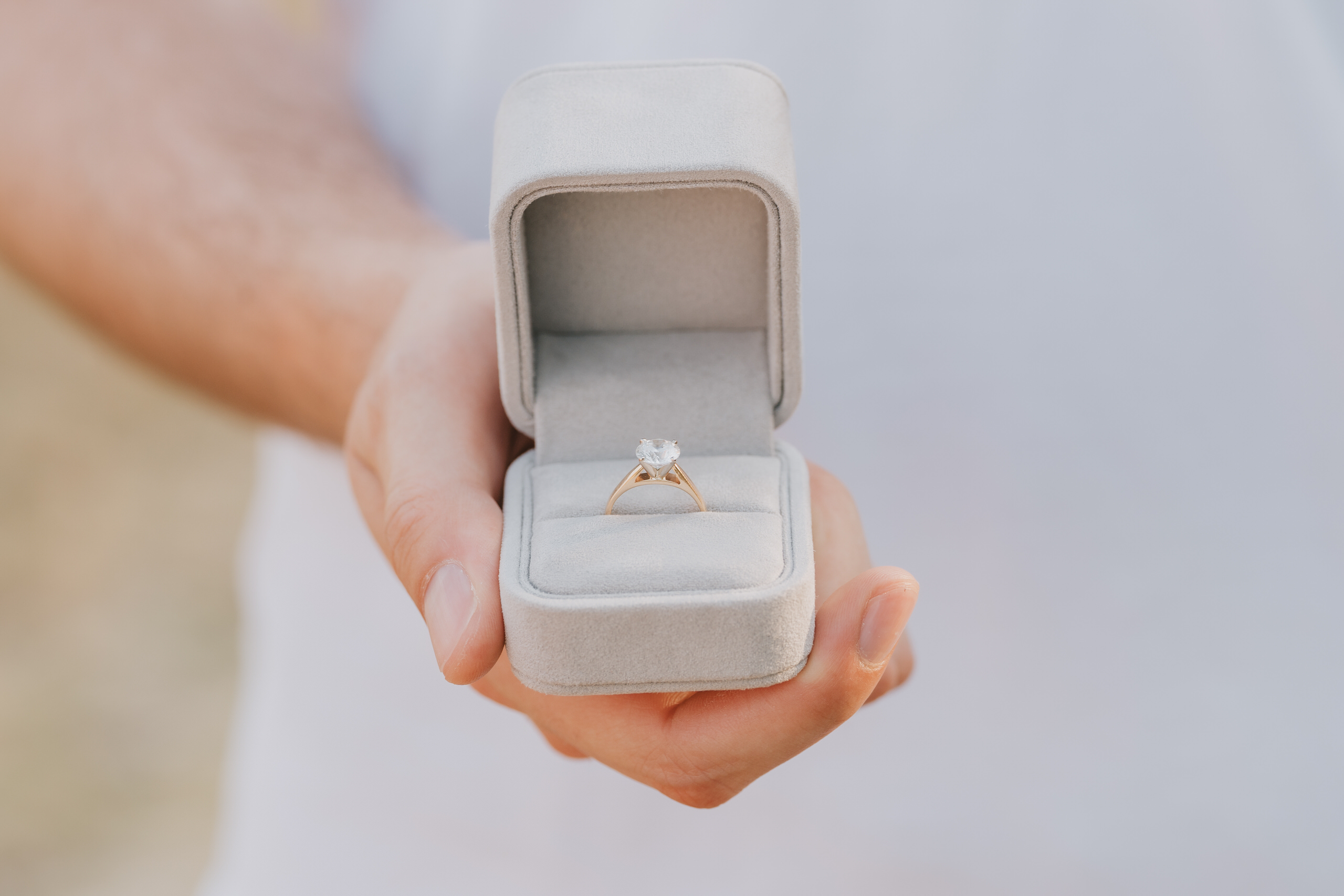 He holds the open ring box, a few seconds before the question