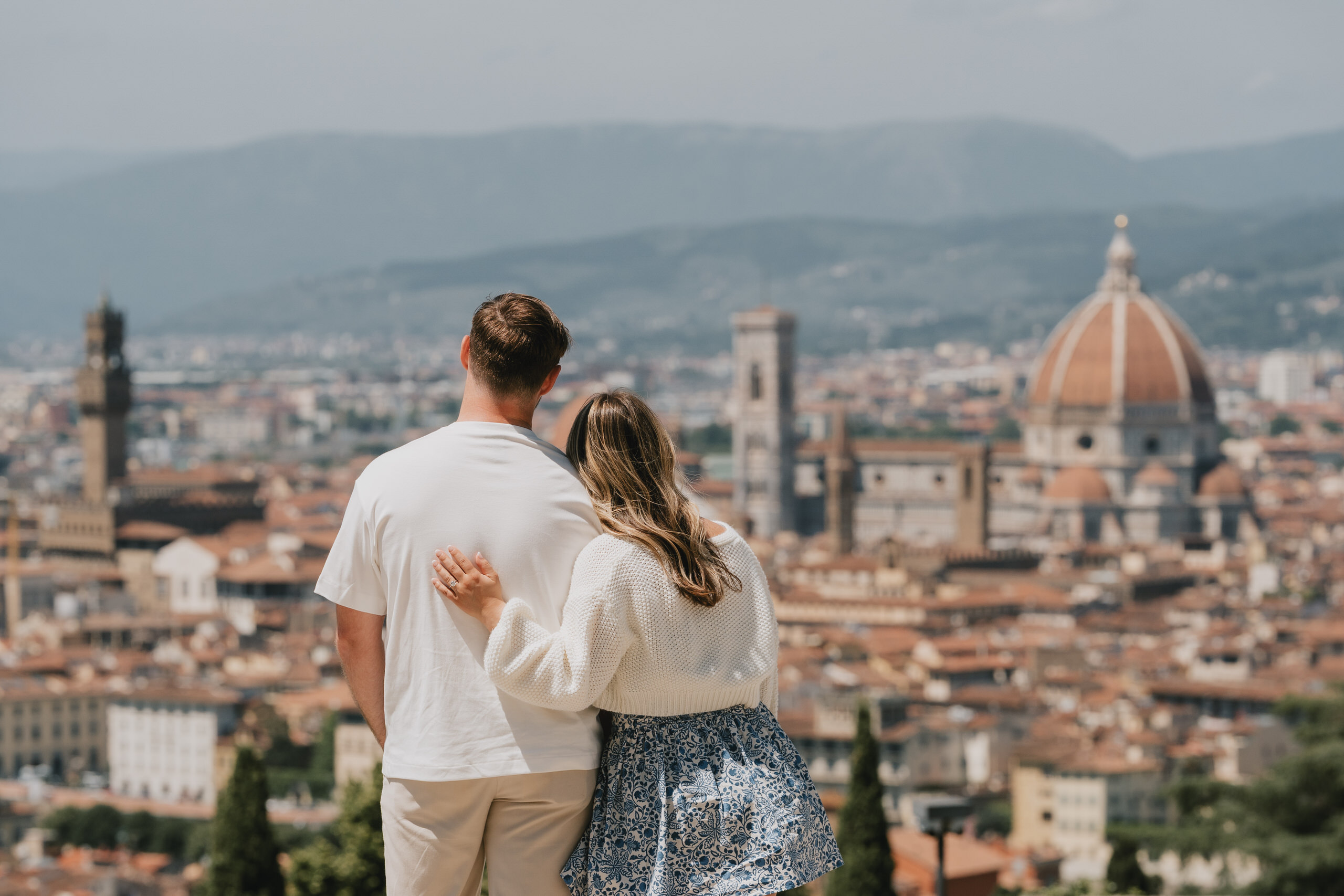 Couple seen from behind looking at the Florence skyline after the proposal