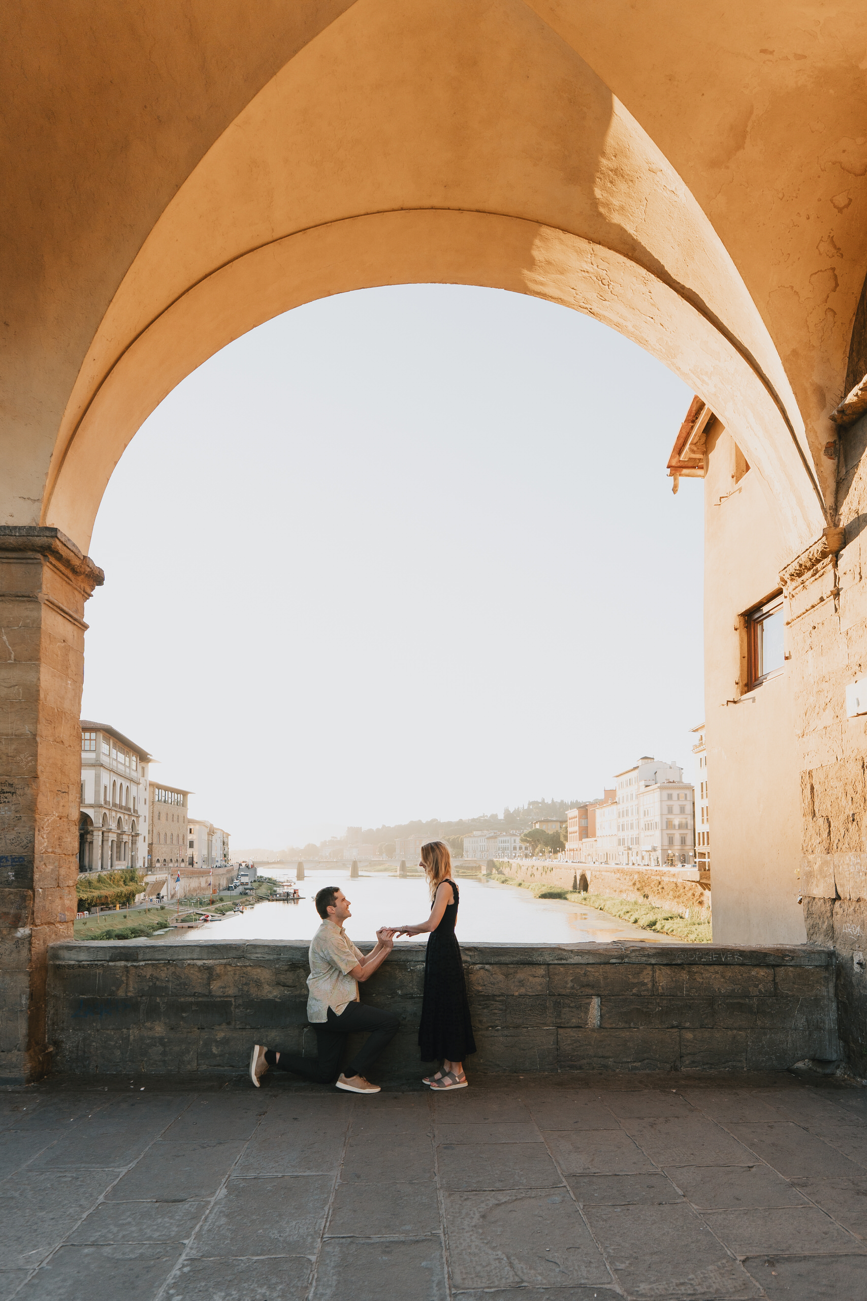 Proposal framed by a stone arch on the Arno in Florence