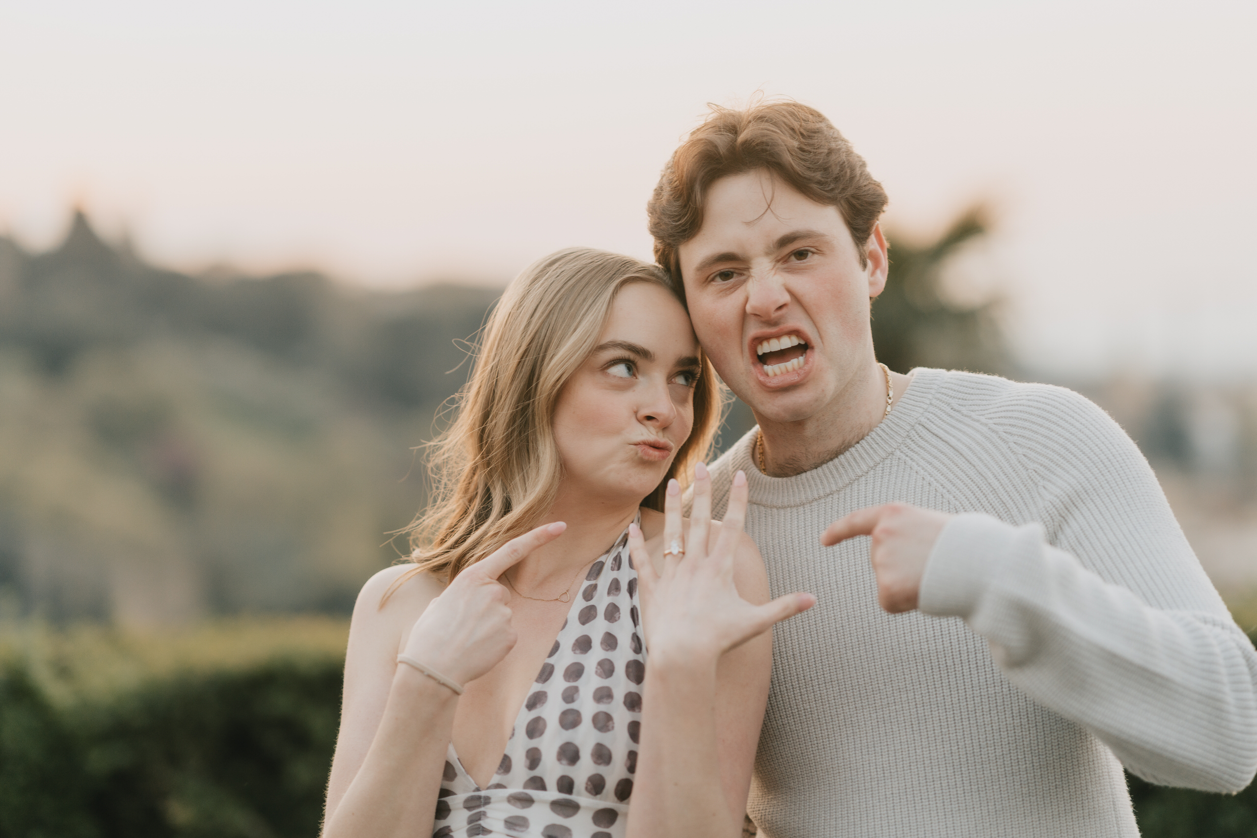 Couple pulling faces and showing the ring after their proposal in Florence
