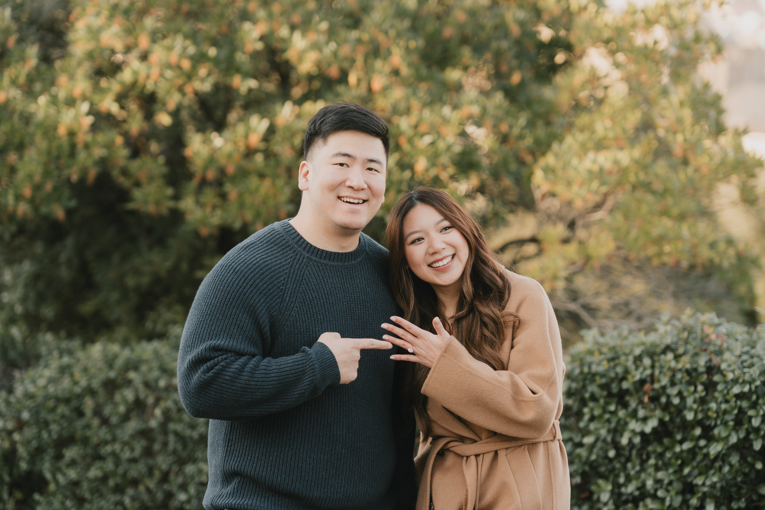Couple pointing at the engagement ring in a Florence garden