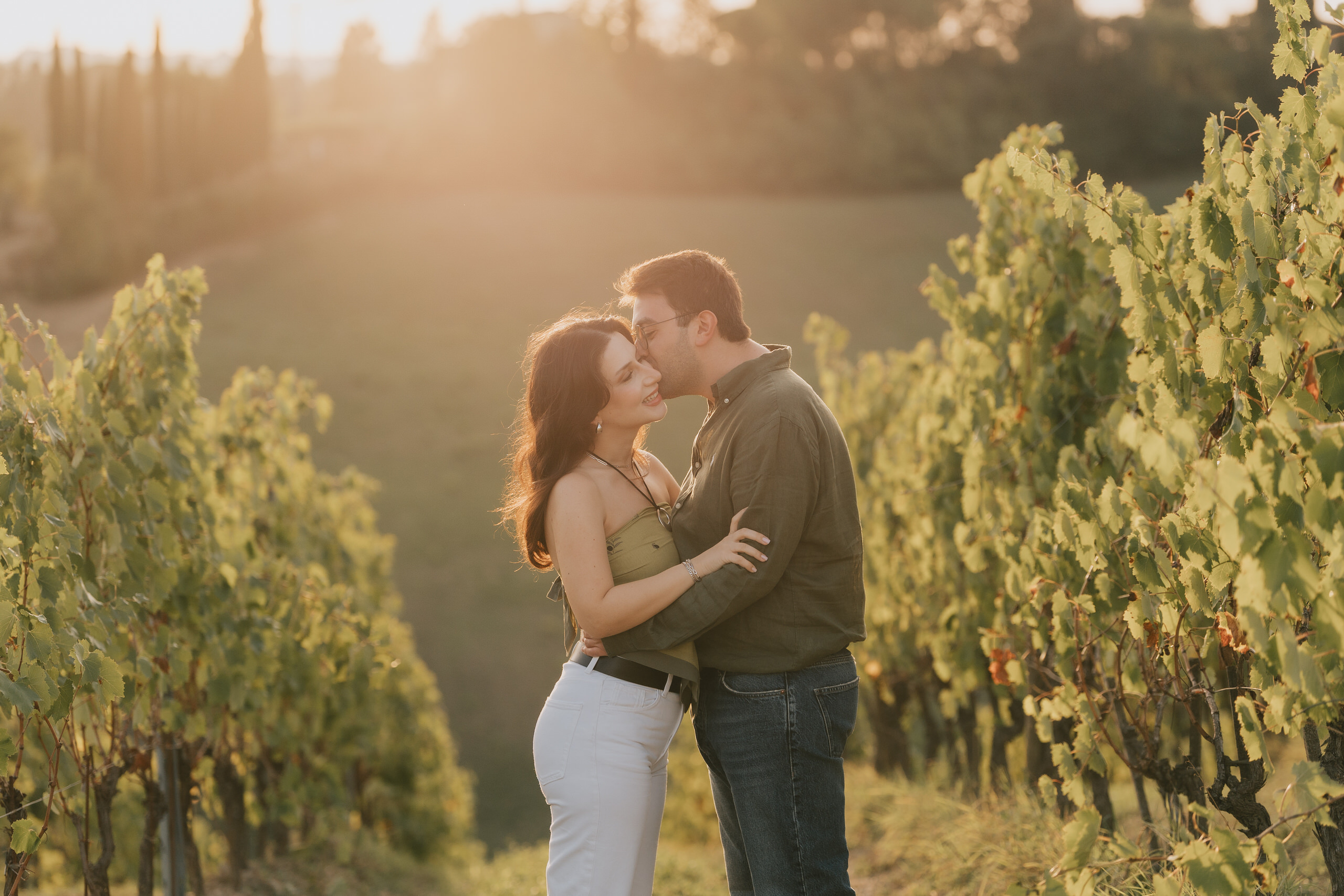 Couple kissing in the vineyards at sunset after a proposal near San Gimignano