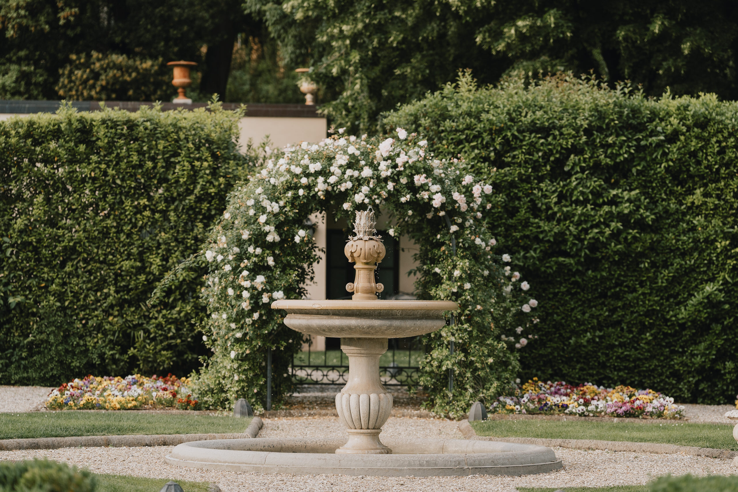 Fountain under a rose arch in the garden of Villa Agape, Florence