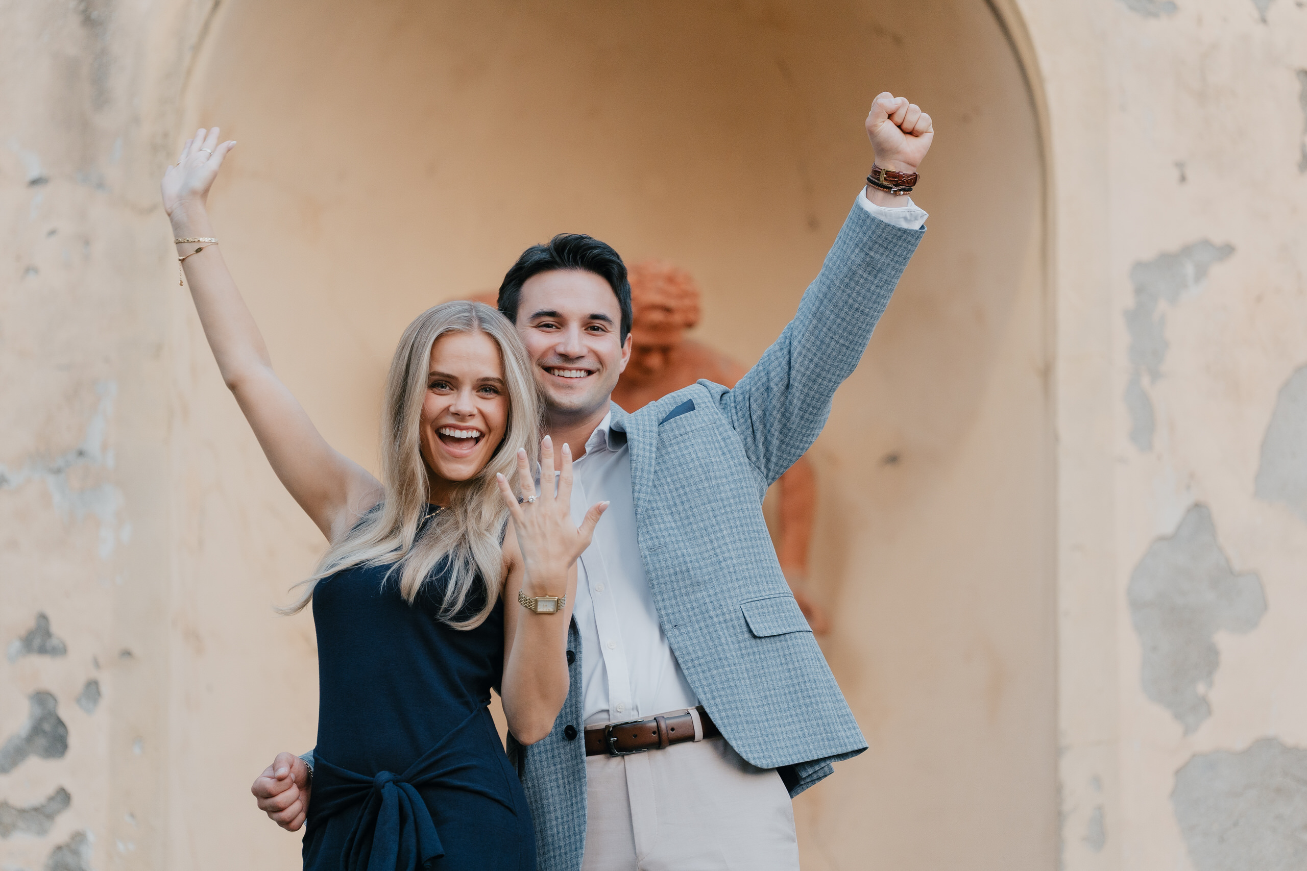 The couple cheering with arms raised in a niche at Villa Agape, Florence