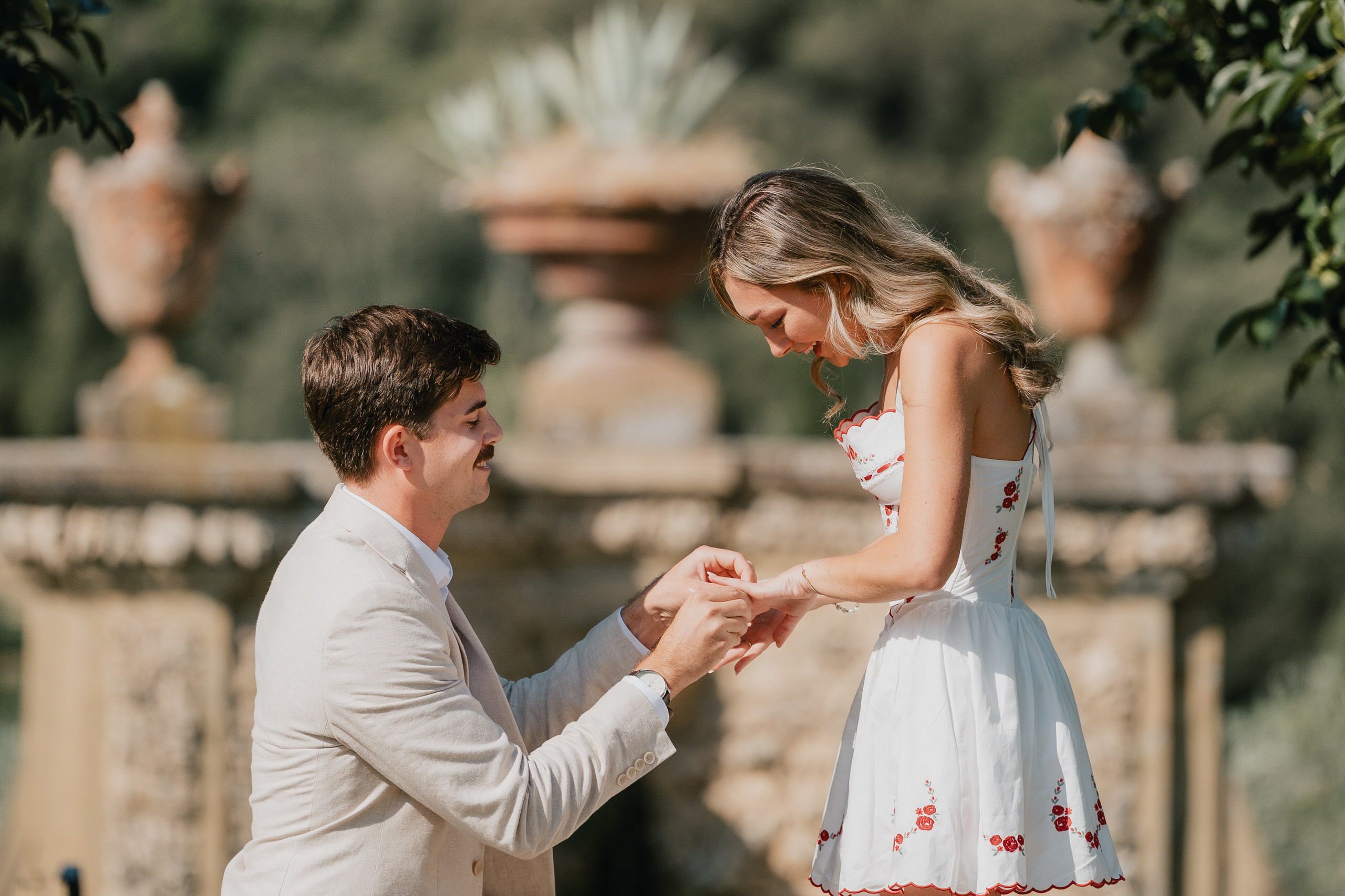 He slips on the ring by the stone balustrade of Villa Il Pozzo