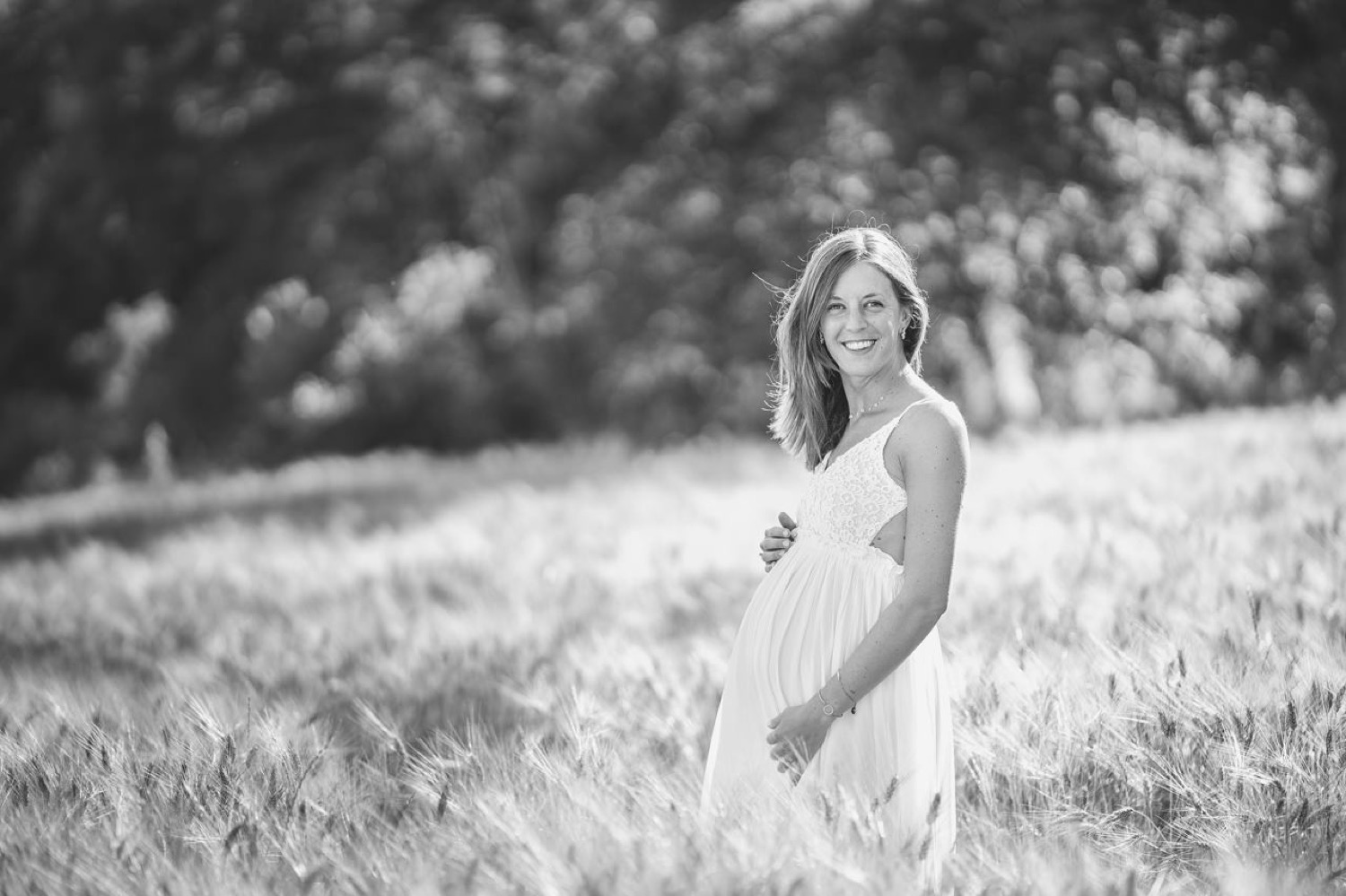 Pregnant woman in a field of dry grass, black and white