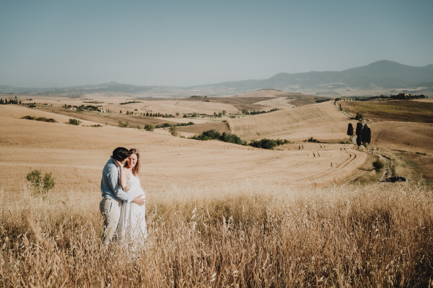 Couple standing in the wheat fields near Pienza