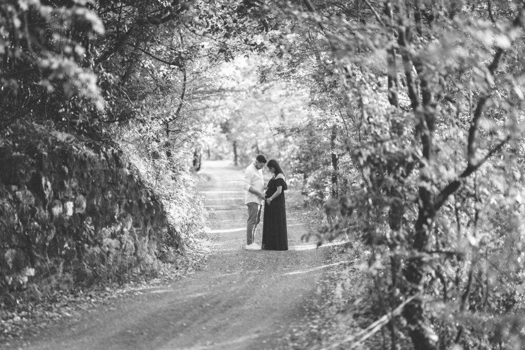 Coppia sotto un viale di alberi, in bianco e nero