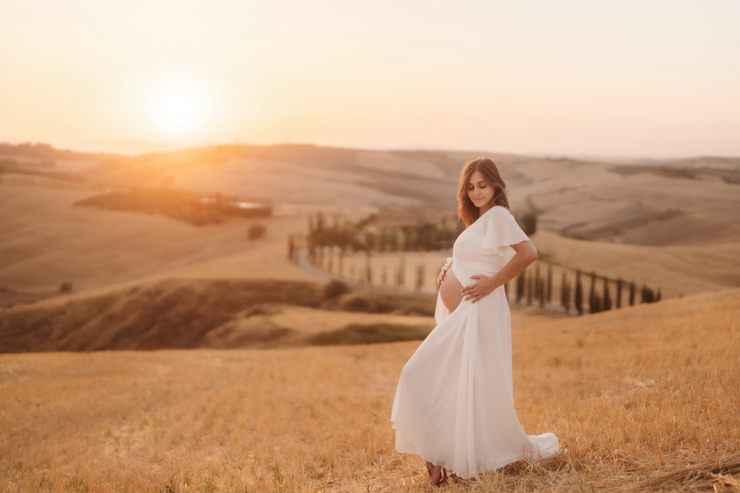 Futura mamma in abito bianco in controluce