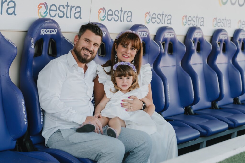 Papà, mamma e bambina sui seggiolini della panchina